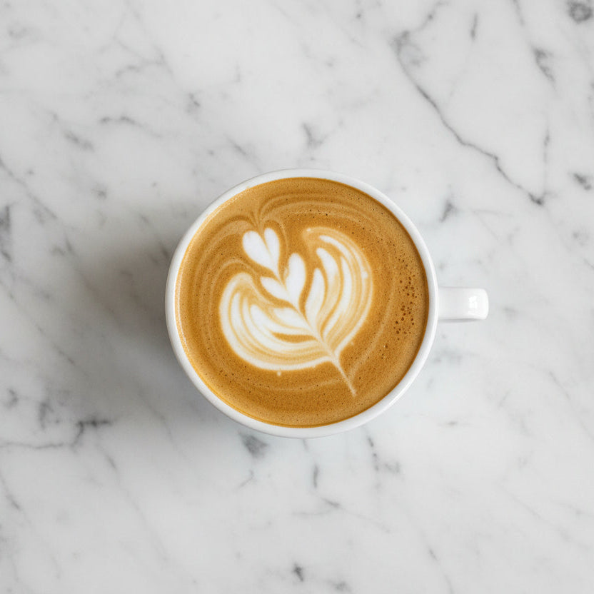 Cappuccino with latte art of a face on a marble surface
